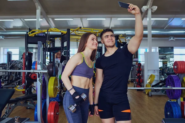 Los deportistas hacen selfies por teléfono en el gimnasio — Foto de Stock