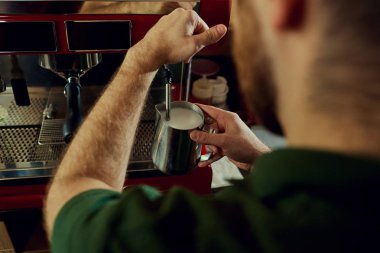 Barmen, barista kahve makinesine sıcak süt yapar