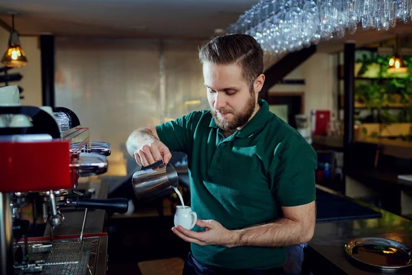 Barkeeper Barista gießt heiße Milch in ein Glas im Café — Stockfoto