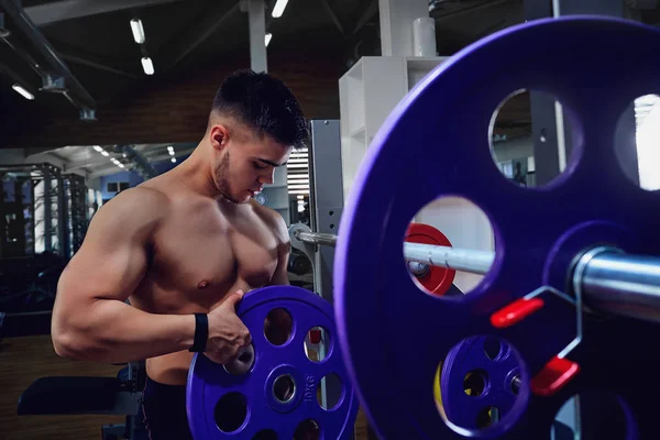 Atlet binaragawan dengan dumbel di gym — Stok Foto