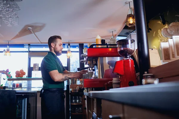 El camarero, camarero, hace una bebida caliente de café en el mostrador del bar en — Foto de Stock