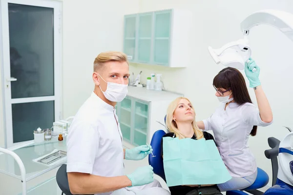 Le dentiste homme et assistante femme traitent les dents à cli — Photo
