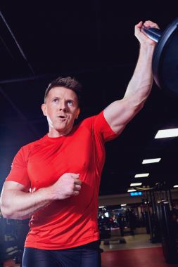 Bir halter salonunda ile egzersizleri yapıyor atletik erkek atlet