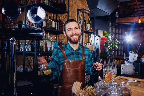 Der Barkeeper lacht und kocht einen Cocktail an der Bar — Stockfoto