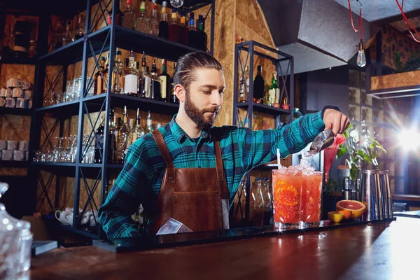 Der Barkeeper lacht und kocht einen Cocktail an der Bar — Stockfoto