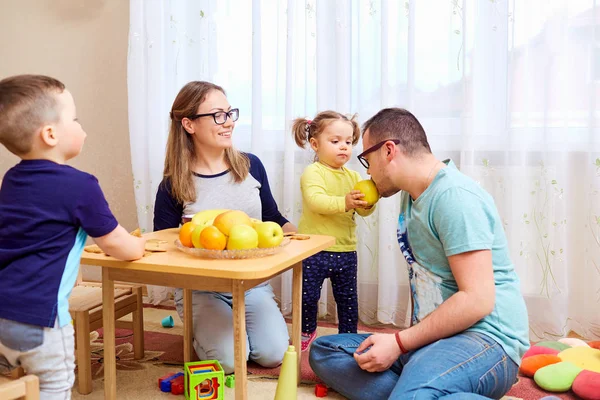 Die Tochter füttert ihren Vater mit einem Apfel im Zimmer — Stockfoto