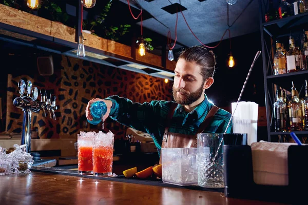 Le barman à la barbe prépare un cocktail au bar — Photo