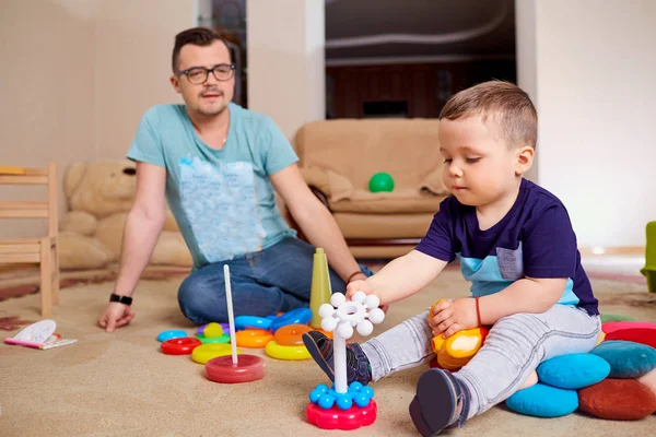 Papá e hijo están jugando en el suelo en la habitación —  Fotos de Stock