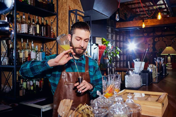 Barman hipster avec une barbe fait un cocktail alcoolisé behi — Photo