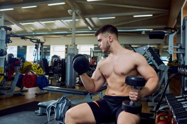 Çocuk jimnastik salonu dumbbells ile egzersizleri yapıyor