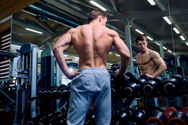 Arkadan görünüş ile sportif bir adamın salonda kasları — Stok fotoğraf