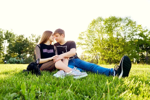 Milující pár objímat sedět na trávě v parku — Stock fotografie