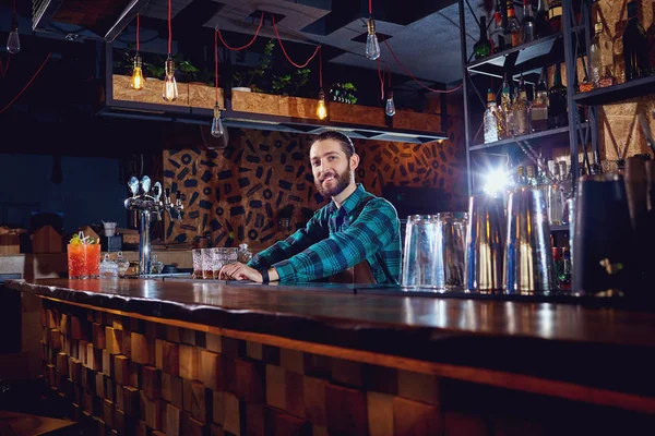 Un barman con barba detrás del mostrador en el bar —  Fotos de Stock