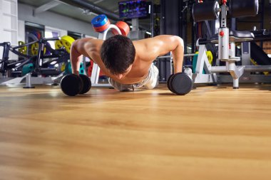 Spor salonunda yerden şınav bir adam yapar