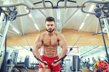 Vücut geliştirmeci simülatör spor salonunda egzersiz yapar
