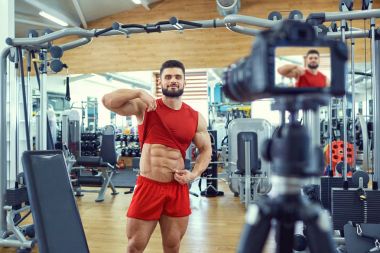 Vlogger atlet vücut geliştirmeci bir video spor salonunda yapar.