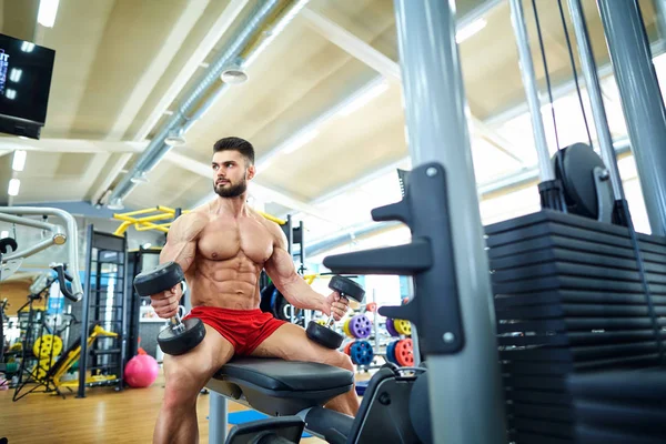 Bodybuilder dengan dumbbells di gym — Stok Foto