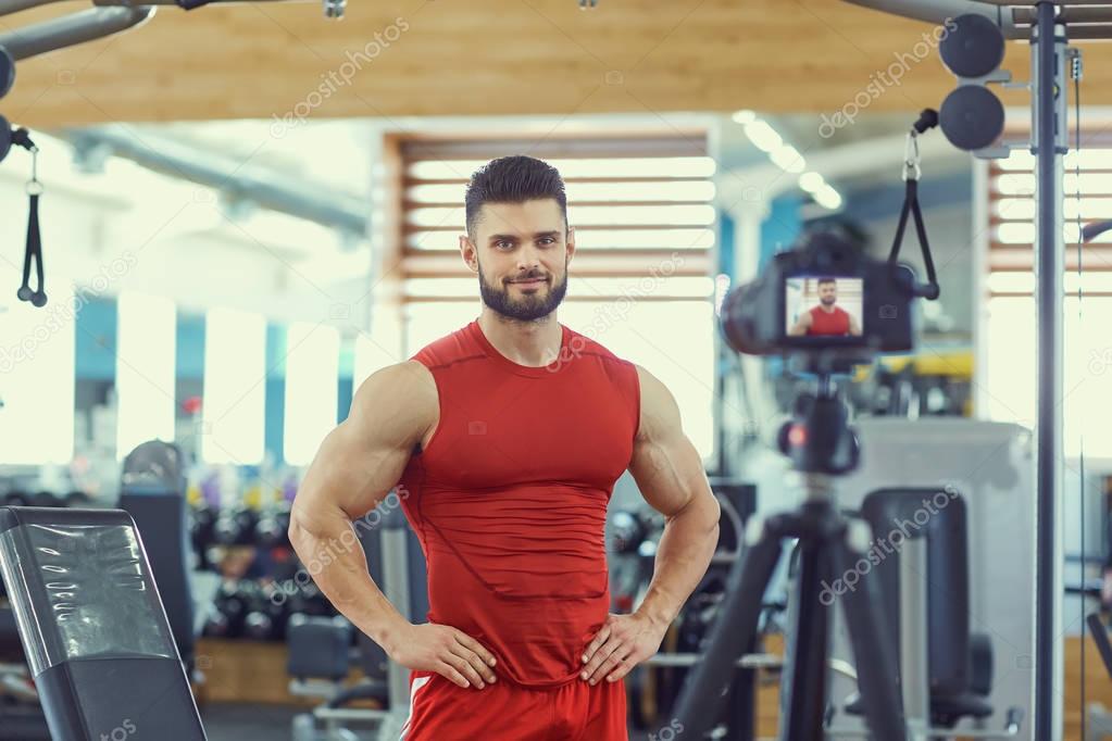 Blogger athlete bodybuilder makes a video in the gym
