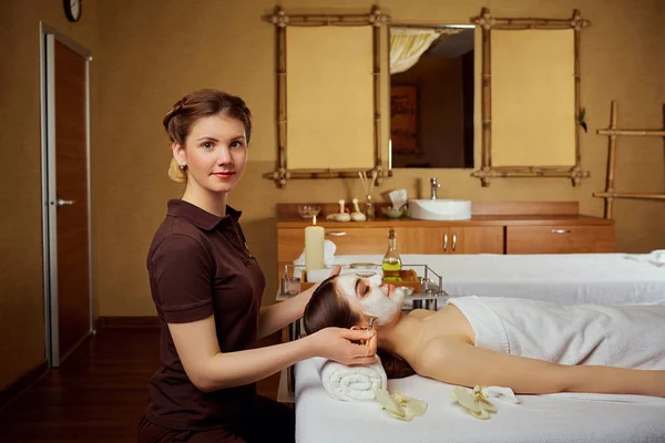 Cosmetologue fait un masque pour une femme dans un salon de spa — Photo