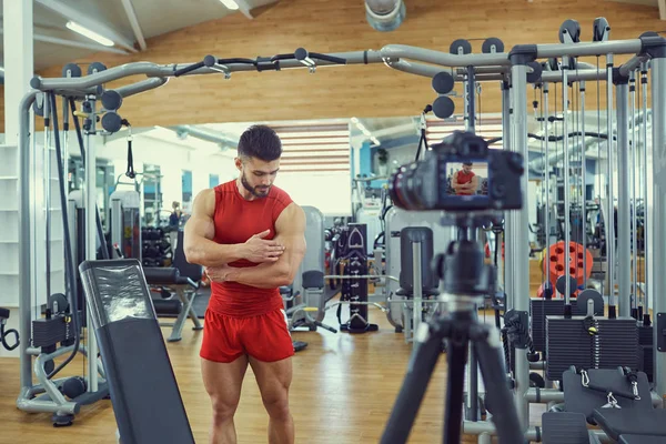 Vlogger athlete makes a video in the gym.