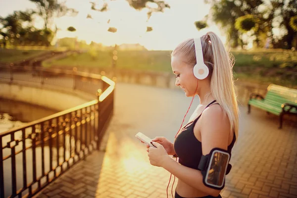 Στάση δρομέα κορίτσι στο πάρκο ακούγοντας μουσική. — Φωτογραφία Αρχείου