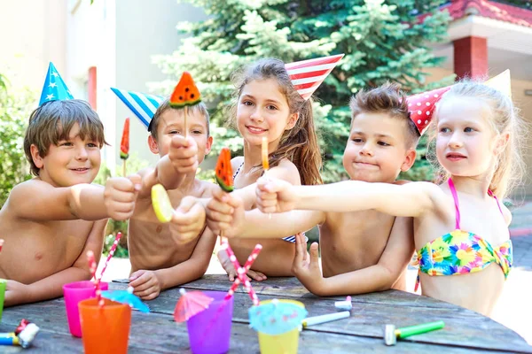 Birthday. Happy children in hats with colorful candy — Stock Photo, Image