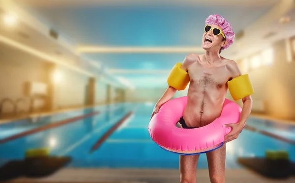 Un hombre delgado y divertido desnudo con un anillo alrededor de la piscina —  Fotos de Stock