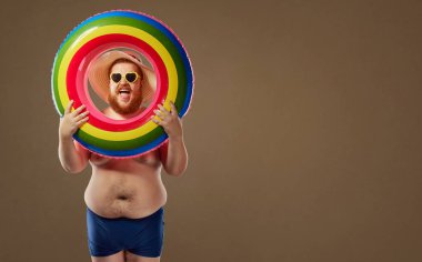 Bir mayo şişme bir daire ile gülümseyen kalın komik adam.