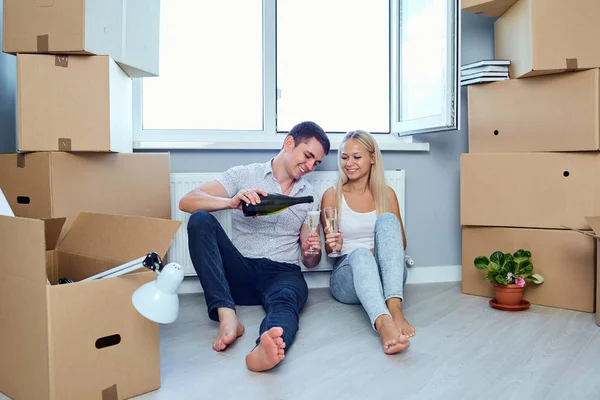 Una coppia felice beve champagne nella stanza di un nuovo appartamento . — Foto Stock