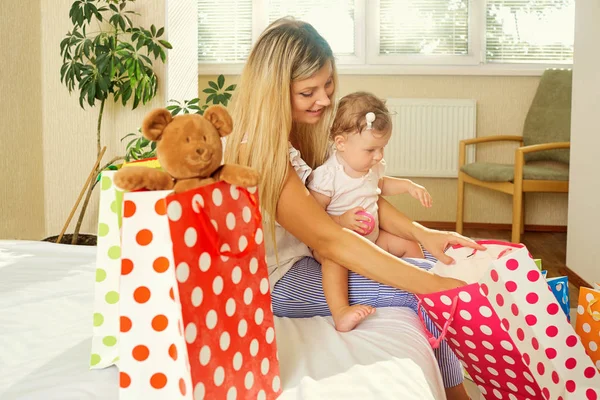 Anya és a baba csomagok megnyitja ajándékokat a szobában th — Stock Fotó