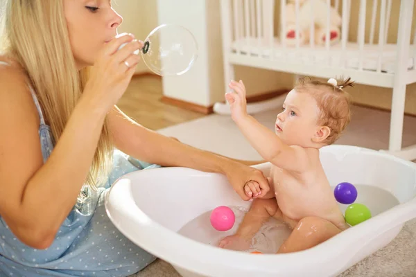 Bébé se baignant dans la salle de bain avec sa mère — Photo