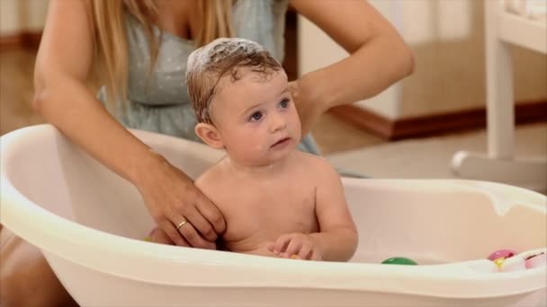 Matka se koupe dítě v koupelně v místnosti — Stock video