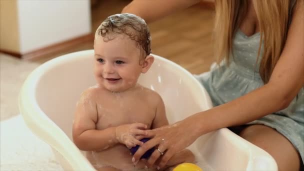Matka se koupe dítě v koupelně v místnosti — Stock video