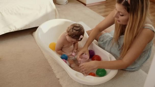 De moeder baadt de baby in de badkamer in de kamer — Stockvideo
