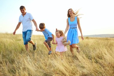Açık havada yürüyüş ve gülümseyerek mutlu bir aile.