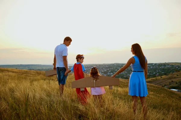 Family in the evening at sunset field in nature. — Stock Photo, Image