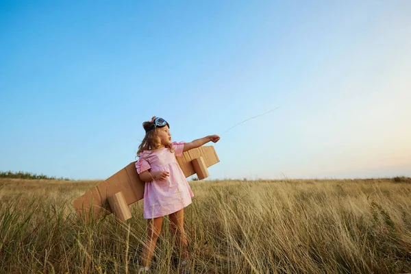 Petite fille en costume de pilotes dans le champ sur la nature . — Photo