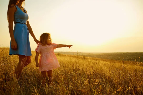 Mutter und Tochter in der Natur bei Sonnenuntergang. — Stockfoto