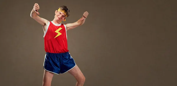 Un chico delgado y divertido con ropa deportiva muestra su dedo hacia abajo — Foto de Stock