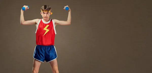 Тонкий смішний хлопець у спортивному одязі з маленькими гантелями — стокове фото