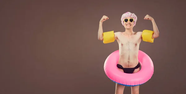 Funny cheerful thin man in a bathing suit with an inflatable cir — Stock Photo, Image