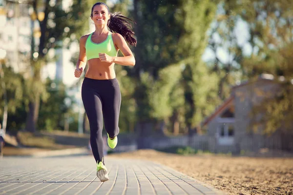 Una corredora morena corre en el parque corriendo — Foto de Stock