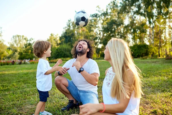 Familia jugando con una pelota en el parque . — Foto de Stock