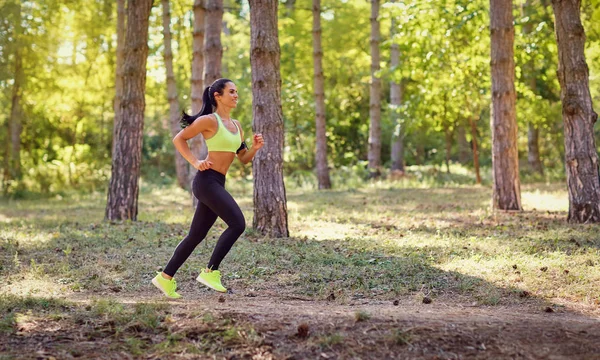 Bir kadın ormanda koşuya ile çalışır.