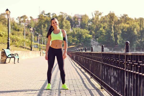 Esmer bir kadın parkta bir atlet koşucusudur.