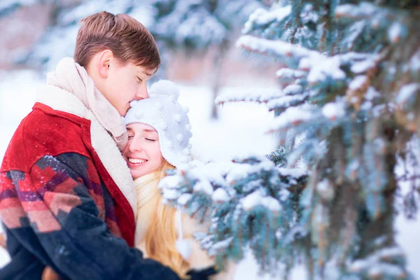 Jovem casal abraçando na neve no parque de inverno . — Fotografia de Stock