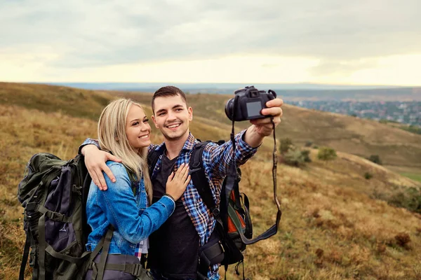 Casal de viajantes são fotografados em uma câmera na natureza . — Fotografia de Stock