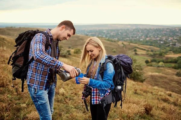 Aantal reizigers zijn thee drinken uit een thermos in de natuur. — Stockfoto