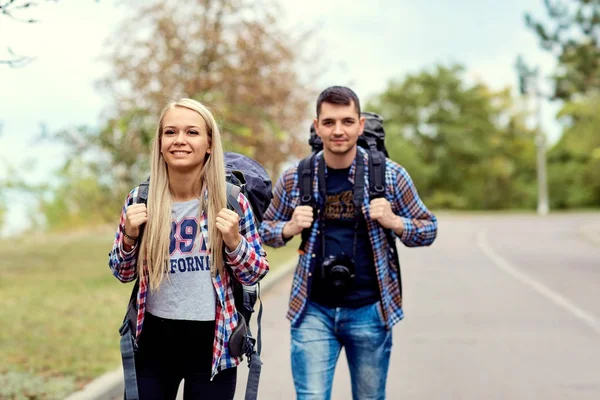 Mladý pár turistů turisty v výlet na silnici — Stock fotografie