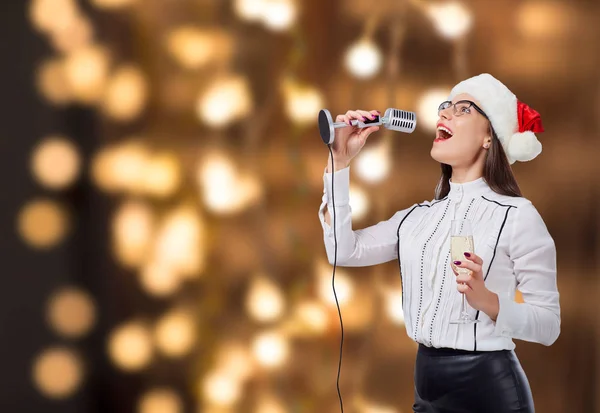 Uma jovem canta em um microfone de karaoke . — Fotografia de Stock